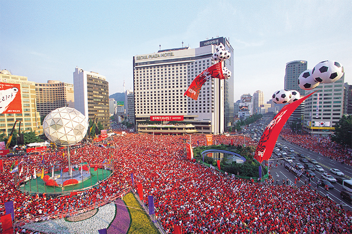 South Koreans supporting the national team in front of Seoul City Hall during the 2002 FIFA World Cup Korea/Japan. Many foreigners said that they were deeply impressed by the fans’ enthusiasm and unity. Still, the Red Devils continue to cheer for the national team ni major tournaments.